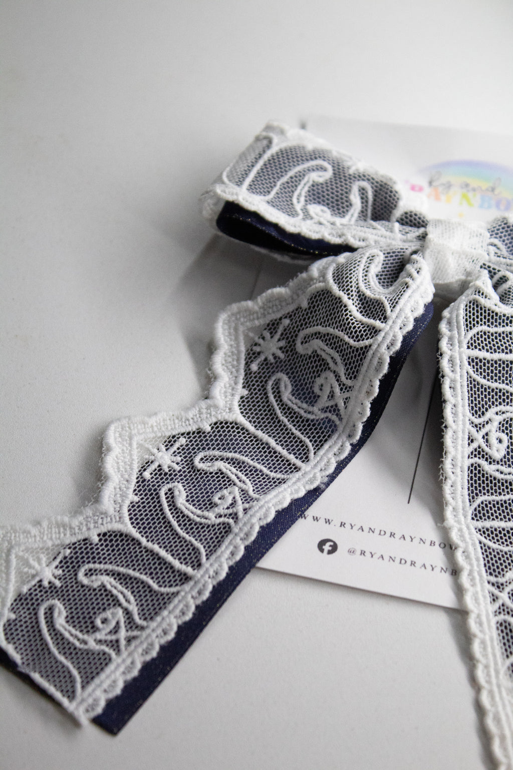 Nativity Lace layered with stardust dark navy satin bow